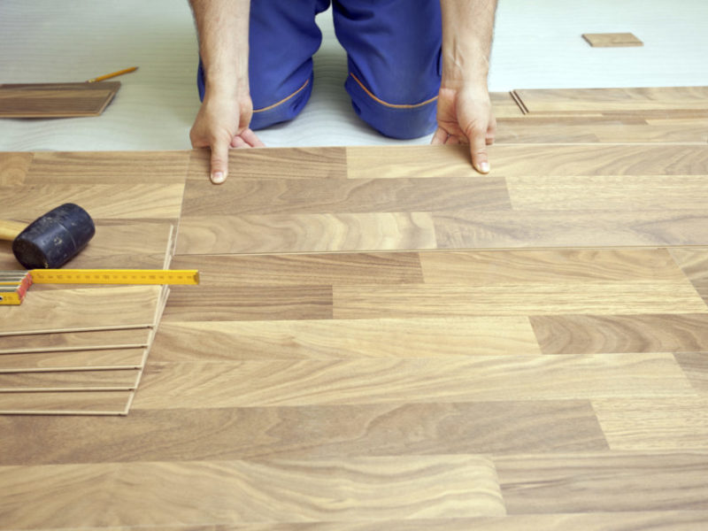 Carpenter installing wooden floor - home improvement